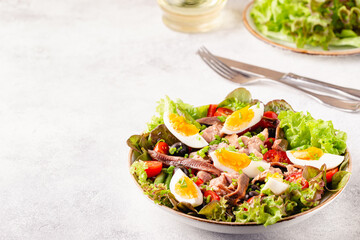 salad Nicoise with tuna, eggs, green beans, tomatoes,  olives, lettuce and anchovies