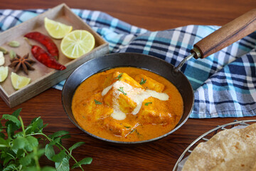 Paneer butter masala , pouring cream on Paneer tikka masala curry Delhi Mumbai North Indian vegetarian side dish Cooking butter paneer made using cottage cheese, Indian spices , footage Kerala, 