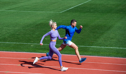 Obraz premium athletic man and woman of sprinters run on running track at stadium, stamina
