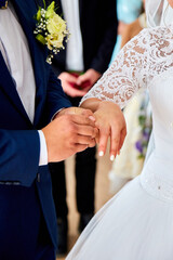 Unrecognizable Bride and groom exchange rings at the wedding