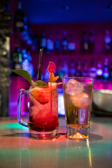 Two cocktails served on a bar counter.