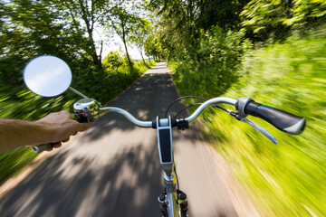 Fototapeta na wymiar Radfahrer fährt einhändig mit hoher Geschwindigkeit