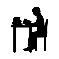 Silhouette of boy reading books at the table