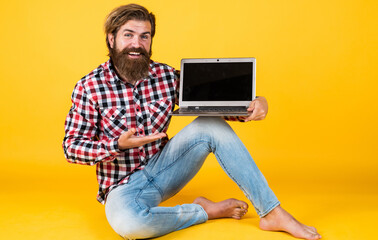 computer master presenting product. digital lifestyle concept. mature student working on laptop. guy work on notebook. online shopping. cheerful hipster use computer. modern technology in business