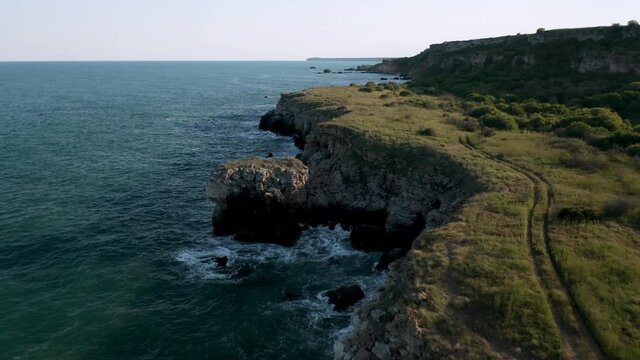 Panoramic video of picturesque rocky coastline with green fields and trees. Spring time at the Black sea coast, Yailata - national archeological and nature reserve, Bulgaria