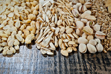 Many kinds of nuts close up. Heap of nuts on a black wooden board. Nuts are stacked on the table.