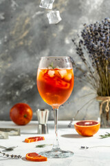Glass of Aperol spritz cocktail on gray background. Italian cocktail with bloody oranges