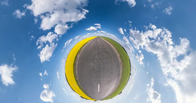 green yellow little planet revolves among fields with beautiful blue sky with white clouds. tiny planet transformation with curvature of space. loop rotate