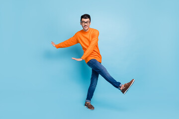 Fototapeta na wymiar Full size photo of satisfied person dancing have fun toothy smile wear sweater isolated on blue color background