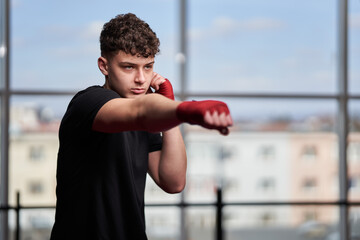 Kickboxer with hands wrapped shadow boxing in the gym