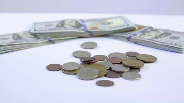 slowmo of coins falling with bills backgound