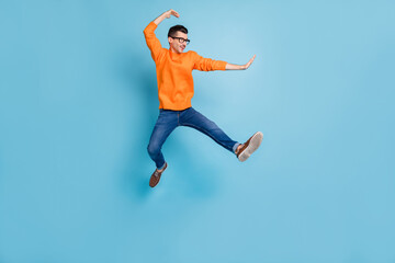 Fototapeta na wymiar Full body profile photo of cheerful man jumping high have fun wear sweater isolated on blue color background