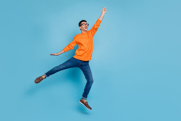 Fototapeta na wymiar Full body profile photo of impressed person fist up jump look empty space isolated on blue color background