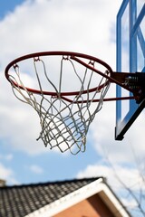 A portrait of an outdoor basketball rim with a net and a plexiglass backboard with blue lines on it...