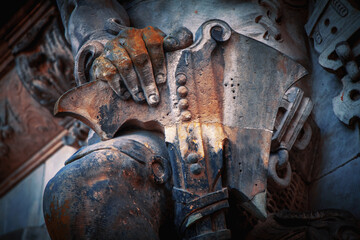 Fototapeta na wymiar Military armor and weapon of grim old guardian soldier. Fragment of an ancient statue. Horizontal image.