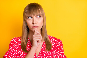 Photo of serious minded pensive woman hold finger chin look empty space isolated on shine yellow...