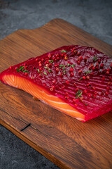 Smoked salmon in one piece with herbs and berries in Scandinavian style on a wooden board