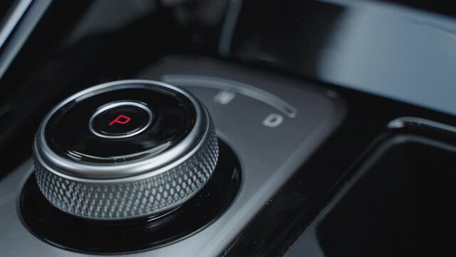 The man hand in close-up switches the transmission of an automatic gearbox. Parking, drive, reverse. Close-up of the male driver hand switches the automatic transmission lever from parking to drive