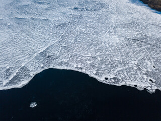 Freezing river. Aerial drone view. Sunny winter day, thin ice on the river.