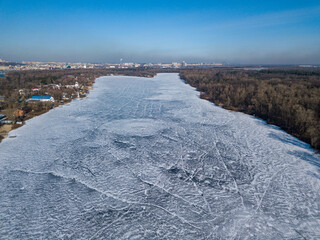 Frosty pattern on the river. Aerial drone view. Sunny winter day, thin ice on the river.