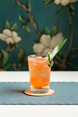 orange cocktail with ice cubes on the table at restaurant