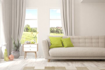White living room with sofa and summer landscape in window. Scandinavian interior design. 3D illustration