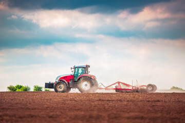 Farmer in tractor preparing land with seedbed cultivator