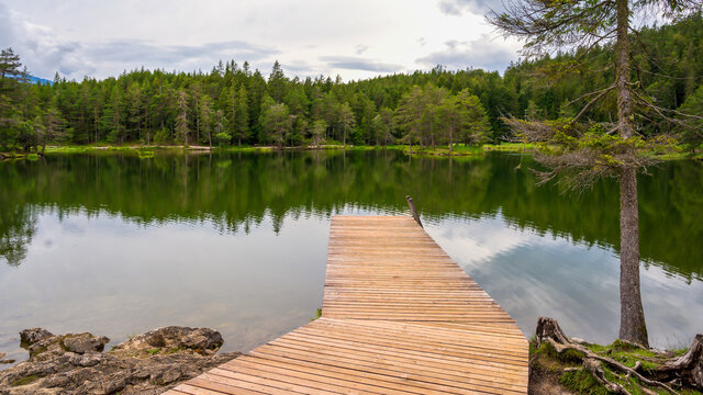 beautiful view of a forest lake with wooden pier M&ouml;serer See Austria