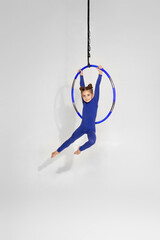 little child girl gymnast shows an acrobatic performance on an aerial hoop © Rychko Yevhen
