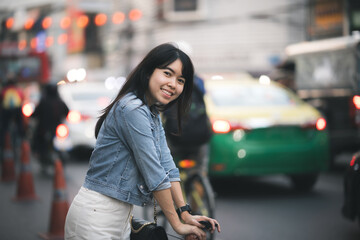Fototapeta premium Beautiful Asian woman who has long hair travels to the festival at Yaowarat Chinatown in Thailand. Street photography of traveler woman at night.