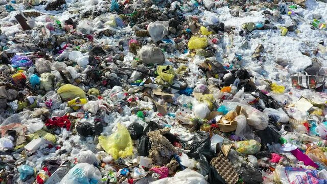 Garbage trash pile, plastic, metal cans and glass bottles scattered on ground with plastic waste bags. Drone low fly over bags with recycle.  Ecological catastrophe for nature. Save planet.