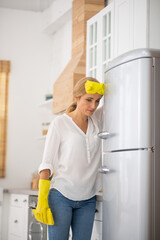 Blonde housewife in protective gloves feeling bad