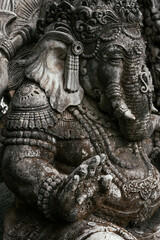 Close-up of an ancient sculpture in Indonesia on the island of Bali. Grey stone sculpture in the old town. Ganesh. Buddhist-related stone statues