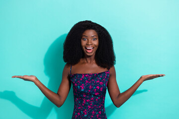 Photo portrait of amazed girl smiling holding copyspaces on palms overjoyed isolated on vibrant...