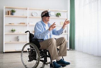 Happy handicapped senior man in wheelchair using VR headset to explore augmented reality at home