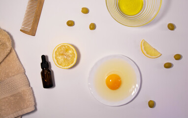 Cosmetic product. Natural ingredients for the preparation of the hair mask: lemon, eggs, olive oil. Olives, comb and hair towel. Hair and skin care mask