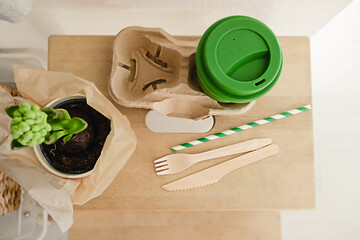 Reusable eco friendly bamboo cup for take away coffee and wooden cutlery set in the modern kitchen. Bring your own cup concept. Zero waste, sustainable lifestyle. Plastic free concept.