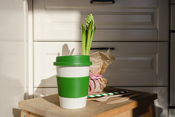Reusable eco friendly bamboo cup for take away coffee and wooden cutlery set in the modern kitchen. Bring your own cup concept. Zero waste, sustainable lifestyle. Plastic free concept.