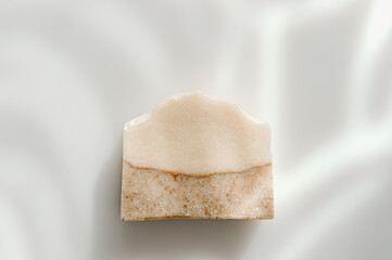 Handmade soap and sunshade shadow on white background. Zero waste, eco friendly cosmetics concept. Vintage color filter