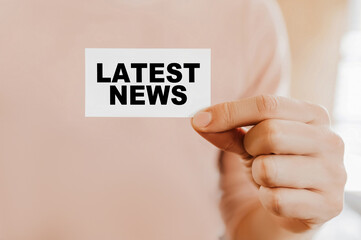 Man holding a business card with Latest News