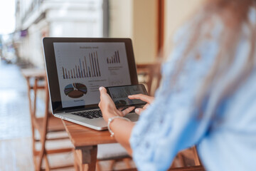 businesswoman with a smartphone analyzing financial data.