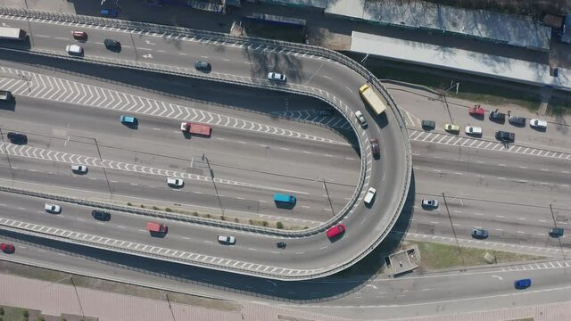 Highway with loop overpass filmed from above with drone. Moderate cars and trucks traffic.
