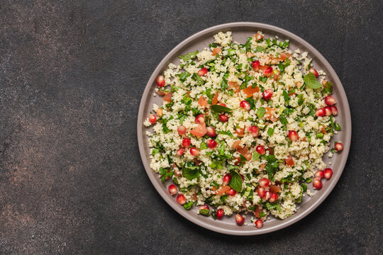 Tabbouleh salad with couscous, tomato, mint, parsley and pomegranate seeds. Traditional Middle Eastern cuisine 