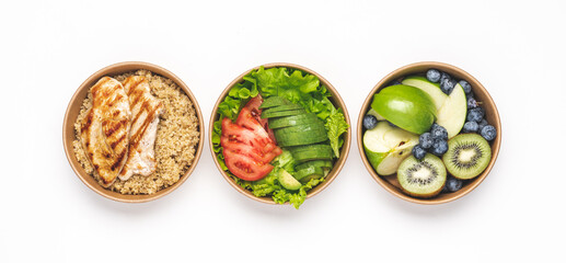 Healthy eating concept. Vegetable avocado salad, quinoa with chicken breast, fruits, berries. Varied meals for every day in eco paper containers