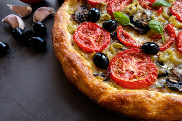 Homemade pizza with tomatoes, mozzarella and basil. Top view on dark stone table. Copy space. Top view.