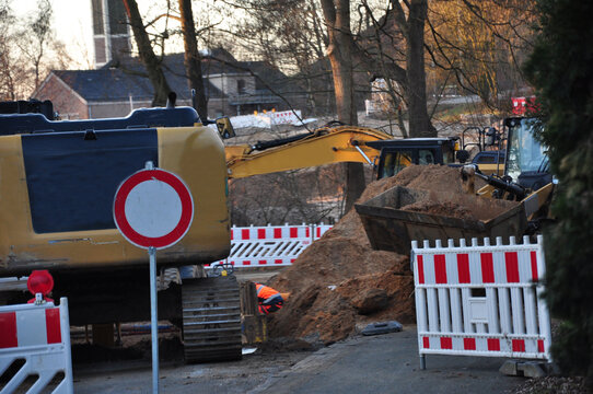 Die Baustellenabsicherung und die Baustellenabsperrung. Die Stra&szlig;enbaustelle und Stra&szlig;ensperrung. Absperrzaun und Durchfahrt verboten Schild vor einer Stra&szlig;enbaustelle.