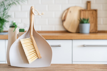 Scoop and brush for cleaning the kitchen table. Modern kitchen interior in the background. House...