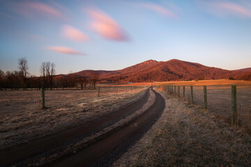 Morning light illuminating Old Rag Mountain of Shenandoah National Park as a man looks on down the...
