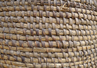 Old hand crafted basket made from dry grass.