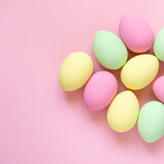 Multicolored painted easter eggs on pink background, top view